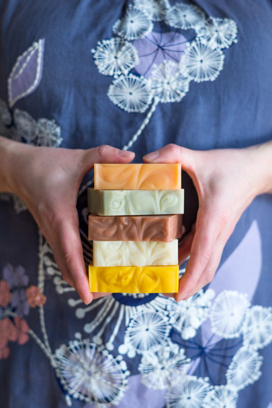 a woman holding natural soap bars